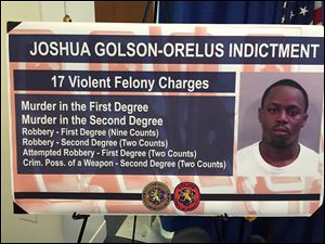 In this Aug. 12, 2015 photo, a board on display at a news conference at the Nassau County District Attorney’s Office in Mineola, N.Y., shows a police handout photo of Jason Golson-Orelus, who evaded authorities for months but was finally arrested after grabbing a stack of bills with a GPS tracking device planted inside. 