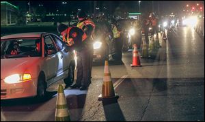 Law enforcement officers from more than a dozen agencies conduct a sobriety checkpoint on Reynolds Road. A federal grant paid for the weekend operation.