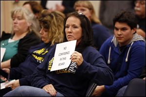 Melanie Garcia, who has three children in Washington Local Schools, holds a sign and then yells out at school board member Jeff Langenderfer, not pictured, after hearing about the resignation of Superintendent Patrick Hickey.