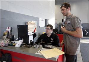 Jason Jaworski, left, and Eric Funk work in the service area at a Yark car dealership.
