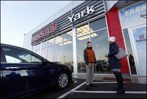 Salesman TJ Kretz and new Honda Accord owner Emily Young of Bowling Green talk outside Yark Automotive. The car dealership chain was selected as the area’s top large workplace.