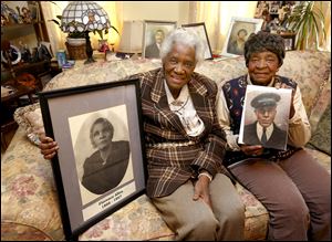Morrell Fonfield, left, holds a photo of their grandmother Florence Allen, while her sister, Ruby Hill, holds a photo of their father, Wilson Allen, in Mrs. Hill’s Toledo home.
