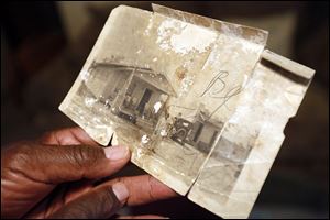 Clyde Hogan holds a picture of the home he was born and lived in until the family moved to Toledo. Many black families found better jobs and a better racial environment in the North.