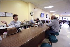 Waitress Terry Muehlfeld, left, throws her arms up in frustration about the economy in Bryan while speaking with Bill Retcher, right, of Bryan, during the lunch hour in Welcome Home Family Dining in Bryan on Febr. 25, 2016.