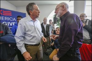 Ohio Gov. John Kasich, left, answers a question for Dale Montri, right, of Ida, Michigan, during a town hall meeting at Monroe County Community College on March 7, 2016.