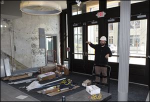 Mike Keedy, director of events and entertainment, works on the first floor of 9 North St. Clair Street. The doors behind him, which open onto North St. Clair Street, will offer a way into the Swamp Shop and the stadium.