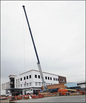 A crane from Jeffers Crane Services is used at a construction site at Eckel Junction Road at Dixie Highway in Perrysburg. The firm just added 50 seasonal workers.