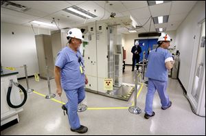 Technicians walk through the radiation protection check point at Davis-Besse nuclear plant.  FirstEnergy Corp. has vowed to stick by its aging Davis-Besse and Perry plants.