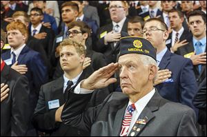 Jack Forster, right, and members of the  Buckeye Boys State salute the flag during the evening program at the Stroh Center at Bowling Green State University.