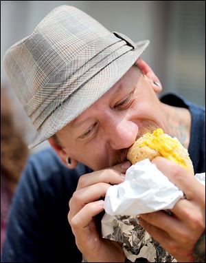 Chris Zielinski of Toledo eats kielbasa during the Lagrange Street Polish Festival.