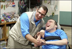 Jeff Alt, outdoorsman, author, and speech pathologist, left, and his brother Aaron Alt joke at Sunshine Communities in Monclova Township during a ‘hootenanny.’ Jeff Alt raised funds for  Sunshine’s first Walk, Run & Rolls 18 years ago. The 19th is set for Sept. 10.