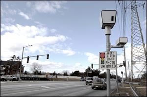 The traffic camera on Douglas Road at University Hills Boulevard in Toledo is active and the city continues to collect fines from people running red lights.