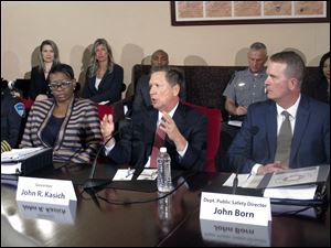 In this 2015 photo, Ohio Gov. John Kasich, center, with former state Sen. Nina Turner, left, announces a plan to establish the first-ever statewide police standards for the proper use of force, recruiting and hiring.