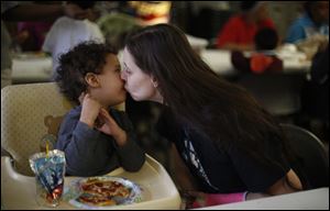 Amanda Workman pauses during lunch to give her son Preston Gould, 2, a kiss.