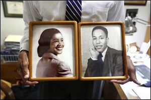 Birdel Jackson holds photographs of his mother, Leslie Ann, and father, Birdel Jackson, Jr., in his Alpharetta, Ga., home. His parents would take him on summer vacations to escape the racial tensions in the South before the family relocated north.  