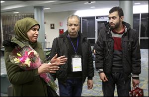 Ghada, left, describes her hope to be reunited with her youngest sons now that she, her husband Khaled, center, and their eldest son Fadi have safely arrived in Toledo.