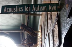 An Acoustics for Autism road sign hangs on the wall during the annual music fundraiser to provide support and information, resources, and financial assistance to families affected by autism.