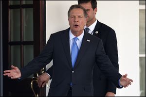 Ohio Gov. John Kasich yells to reporters as he arrives at the White House in Washington Feb. 24.
