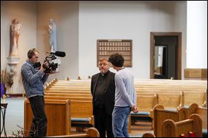 The Rev. Todd Dominique of the St. Wendelin Catholic Church in Fostoria, center, shows videographer Philipp Majer, left, and Max Kern the St. Wendelin Catholic Church in Fostoria. 
