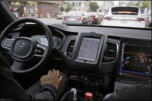 An Uber car in driverless mode waits in traffic during a test drive in San Francisco. Uber said it is resuming its self-driving car program in Arizona and Pittsburgh after it was suspended following a crash last weekend. The company had also grounded self-driving cars in San Francisco over the weekend, but they resumed operating earlier Monday. 