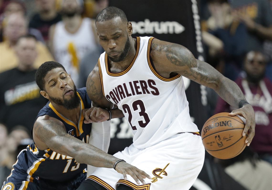 Indiana Pacers' Paul George, left, reaches for the ball as Cleveland Cavaliers' LeBron James drives to the basket in overtime during an NBA basketball game, Sunday.