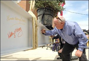 Seneca County Commissioner  Mike Kerschner signs a construction beam during a ‘Topping Out Ceremony’  at the Justice Center being built at the site of the courthouse that was razed in 2012.