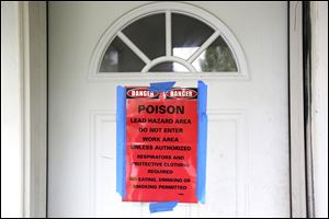 A sign posted by the Toledo-Lucas County Health Department covers the door at 530 Acklin Avenue and warns people to stay out because of lead contamination.