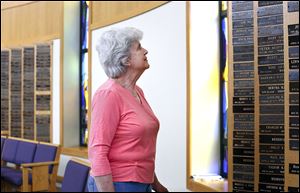 Cathy Sperling surveys memorial plates of her parents and other relatives in the B’nai Israel synagogue. Her parents’ histories are included in a book in part to celebrate the Sylvania Avenue congregation's 150th anniversary.