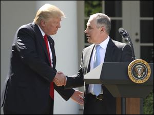 President Donald Trump shakes hands with EPA Administrator Scott Pruitt after pulling the United States from the Paris climate change accord.