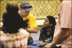 Pastor Jacob Hawes, left, talks with Kenneth Roach, 12, during weekly children's church service at Family House.