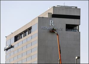 Workers install the sign on the Renaissance Toledo Downtown Hotel.