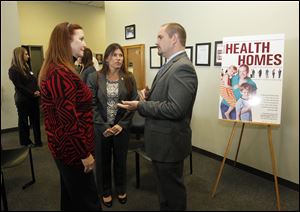  (R), left, speaks with  Tracy J. Plouck, center, director of the Ohio Department of Mental Health, speaks with then-State Representative Barbara Sears, left, and John B. McCarthy, right, State Medicaid Director, in 2012.