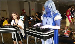 Kat Zielinski, 13,  left, and Ashlyn Slaviero, 14, play DJ Hero2 during the Glass City Con 7  at the SeaGate Convention Centre downtown.