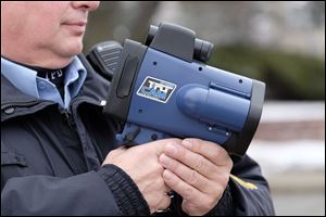 A police officer holds a handheld speed camera. Toledo sent refunds totaling nearly $34,000 for 270 speeding tickets issued at one location on Glendale Avenue.