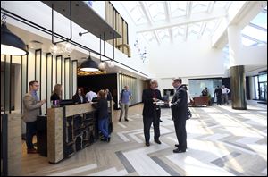 Jeffrey Hassan, general manager, right, speaks with Sam Selim, left, of Chicago, in the busy lobby of the Renaissance Downtown Toledo Hotel on the first day of the official opening on August 2.