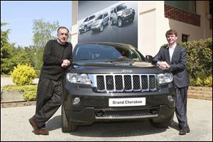 Fiat Chrysler CEO Sergio Marchionne leans on a Grand Cherokee Jeep near Turin in 2011, two years after the Italian company took over the Jeep brand.