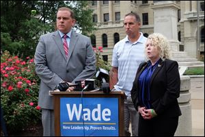 Toledo mayoral candidate Wade Kapszukiewicz, left, and John Clemons listen to Laurie Clemons speak about her son's death from opioid addiction. Kapszukiewicz says that as mayor of Toledo, he would join other communities in a lawsuit against 