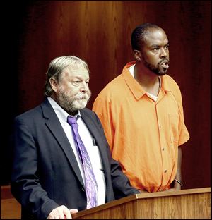 Shellton Hicks, right, whose son was killed in June, stands last month with public defender James MacHarg in Toledo Municipal Court on new charges. The elder Hicks previously shot and killed another teenager.