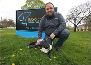 Richard Stewart, director of the Lucas County Canine Care and Control, outside the pound in Toledo, Ohio on April 21, 2017. With him is Robin, a nine-month-old Pit Bull mix that is available for adoption.  