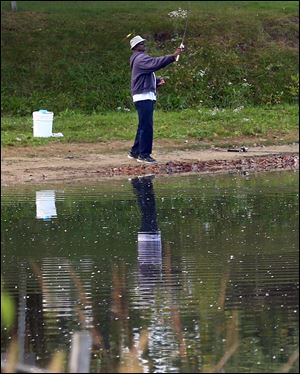 A fisherman casts his line into the lake in Olander Park. Sylvania voters will decide a 0.8-mill property levy for the parks.