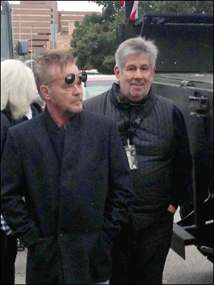In this photo, singer John Mellecamp, left, is shown with rock photographer-tour manager Harry Sandler, right, along Jackson Street in downtown Toledo on Oct. 21, 2016, moments before Mellencamp spoke to the Tent City crowd at the beginning of the 1Matters one-mile walk.