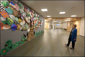 Lynn Fisher, head of school at West Side Montessori School, views student art work on the wall in the school's new safe room Thursday, October 19, 2017 in Toledo.