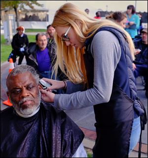 Frank Coley gets his hair cut by Clay High School cosmotology student Emily Zacharias during Tent City at the Civic Center Mall in Toledo. 