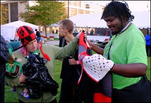 Trey Houston, right, shows a blanket he chose for his friend's baby during Tent City at the Civic Center Mall in Toledo. 
