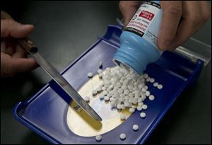 A pharmacy technician fills a prescription for an anti-diarrhea medication at a pharmacy, in Sacramento, Calif.