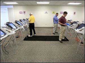 Election board workers prepare machines at the Lucas County Board of Elections.