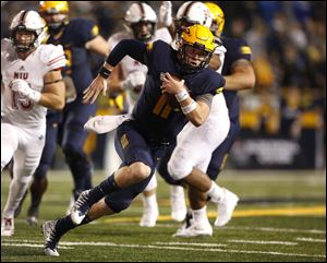 Toledo's Logan Woodside finds running room during Thursday's game at the Glass Bowl against Northern Illinois.