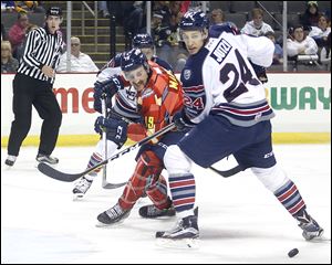 Toledo's Colin Martin, left and Kalamazoo's Jon Jutzi look over to the puck during a game this season at the Huntington Center. The Walleye have traded Martin to Brampton.