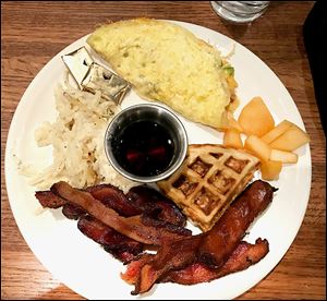 Selections from Granite City Food & Brewery’s Sunday brunch, clockwise from top: build your own omelet, cantaloupe, build your own waffle, sausage and bacon, and reggianno hashbrown potatoes.