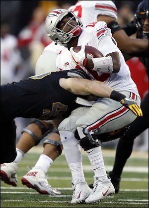 Ohio State quarterback J.T. Barrett is tackled by Iowa linebacker Josey Jewell, left, during a loss last Saturday that sent the Buckeyes to No. 15 in the CFP rankings.